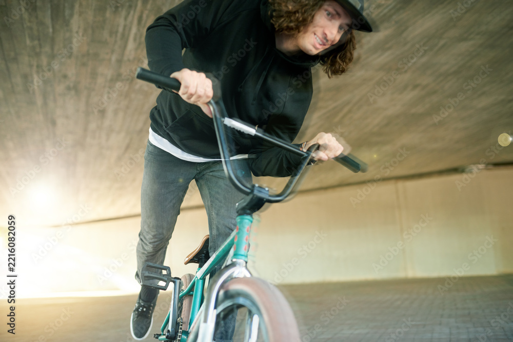 Naklejka premium BMX, motion blur and ride with man on bike for activity, adrenaline hobby or sports training. Exercise, risk and speed with extreme person on bicycle underground for action, cycling or energy