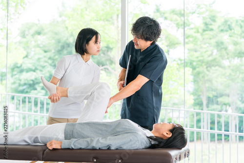 マッサージ,理学療法の研修を受ける若い女性スタッフと教える理学療法士の男性