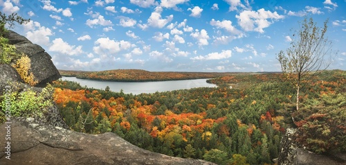 An elevated, panoramic view from a cliff looking over the forests and lakes of Algonquin Provincial Park during autumn in Ontario, Canada