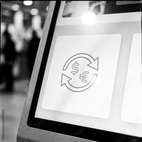 Modern currency exchange terminal interface showing dollar to euro conversion icon on a digital kiosk screen in monochrome.
