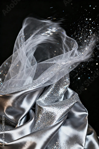 Elegant silver glittering fabric wave on black background