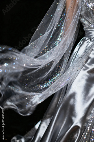 Elegant silver glittering fabric wave on black background