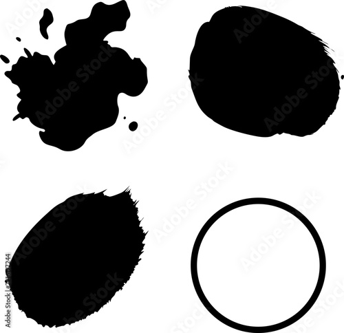Four distinct black ink shapes including splatters and a circular brush stroke isolated on a plain white background