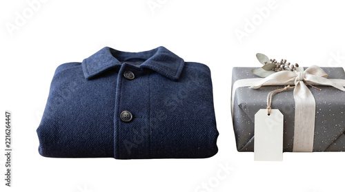 Folded blue wool winter jacket next to wrapped gift box