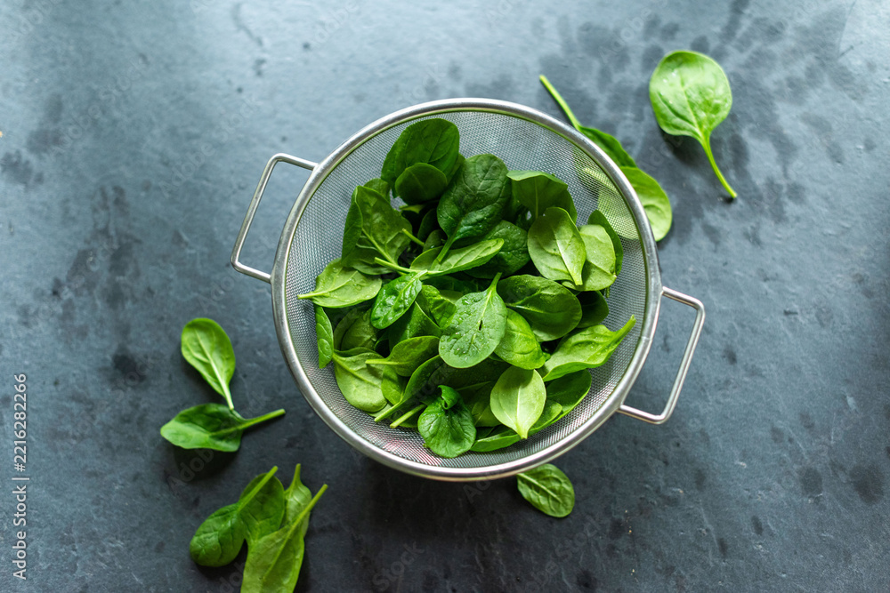Fototapeta premium Fresh spinach leaves in colander