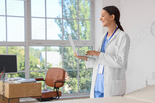 Telemedicine and digital healthcare, smiling doctor using laptop for remote p...