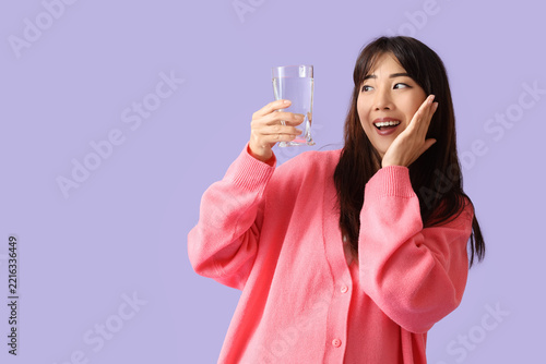 Hydration and wellness, young woman holding a glass of water with a surprised...