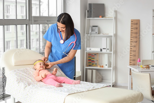 Pediatric healthcare and infant development, nurse measuring baby head circum...