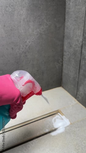Cleaning in Progress: A Close-Up View of a Hand Holding a Cleaning Spray Bottle with Foam on a Surface, Showing the Effort to Maintain Hygiene and Cleanliness.