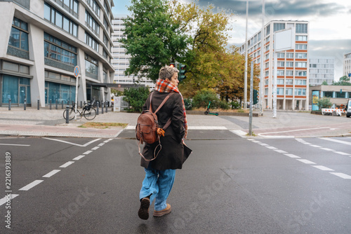 Person walking on city street near buildings in an urban area 