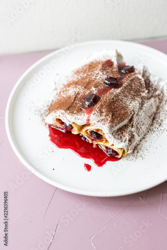 Traditional Moldovan layered dessert Căciula lui Guguță with sour cherries and cream 