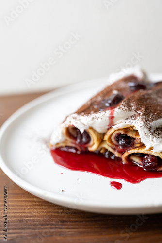 Traditional Moldovan layered dessert Căciula lui Guguță with sour cherries and cream 