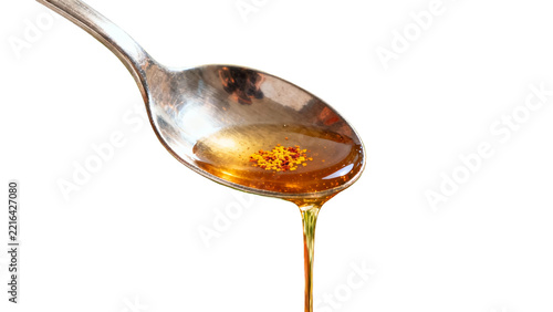 Spoon pouring honey with spices isolated on transparent background
