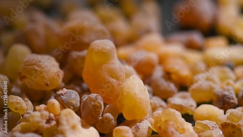 Olibanum Frankincense resin backdrop, Boswellia sacra background. Frankincense or olibanum aromatic resin for incense and perfumes, dark rotating backdrop, design, religion 