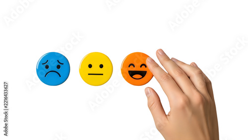 Hand selects happy face emoji from a selection of emotional icons with shallow depth of field