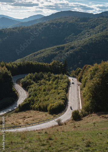 Winding mountain road with hairpin turn Podkova and motorcyclists near Dobšiná, Slovak Ore Mountains, Slovakia