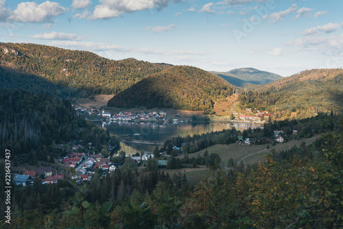 Dedinky village on the shore of Palcmanská Maša reservoir surrounded by forested hills in warm early autumn light, Slovak Paradise, Slovakia