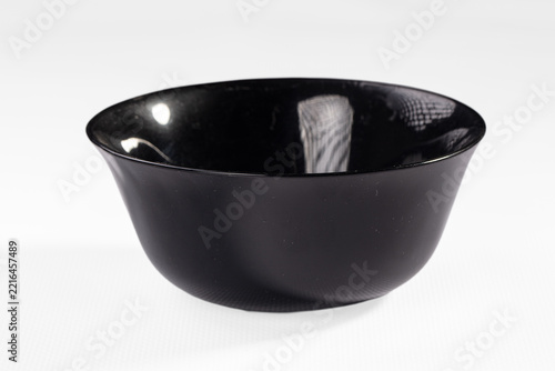 Glossy black ceramic bowl with reflective interior surface isolated on white background for product display