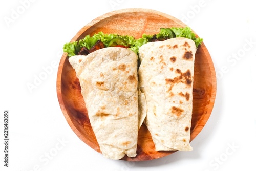 wrapped tortillas on a plate isolated on a white background . Top view