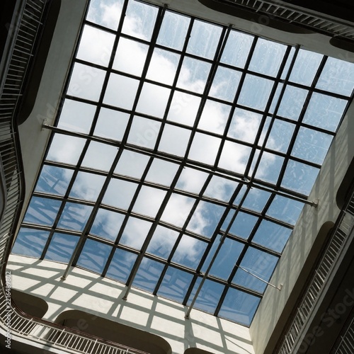 Skylight glass roof with grid structure and clouds