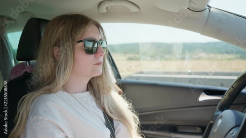 Woman driving car on sunny road trip slow motion wearing sunglasses 35 years old