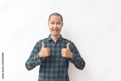 Obraz na plátně Asian man showing thumbs up gesture with positive expression