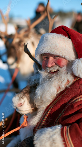 Santa Claus with rosy cheeks beaming with joy on a snowy journey with his trusty reindeer, with copy space