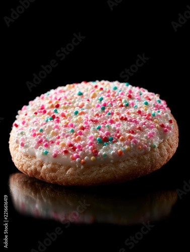 Delicious Cookie with Colorful Sprinkles on a Glossy Black Background