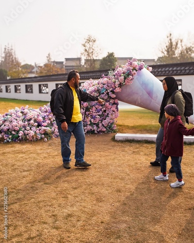 Father showing kids the flowers flowin in the garden in Shanghai, China