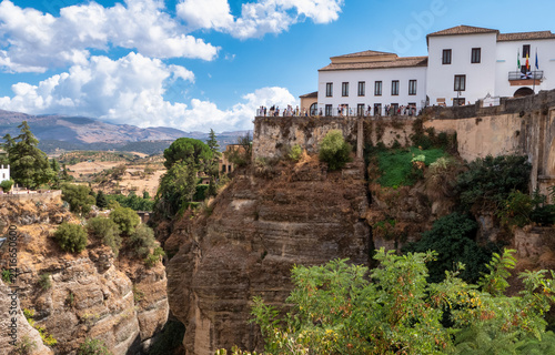 white buildings perched on steep cliff overlooking gorge in ronda spain