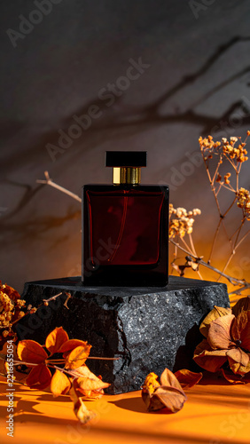 Dark Moody Luxury Autumn Fragrance: Moody elegant dark amber glass perfume bottle fragrance display on stone