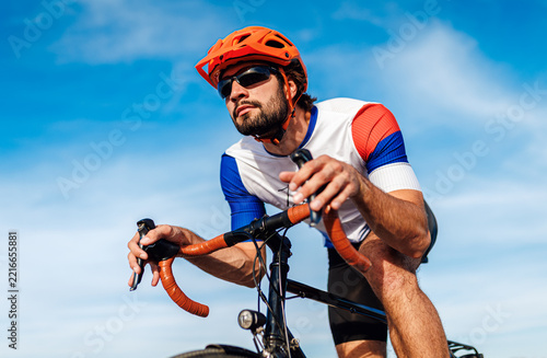 Low angle view of cyclist riding road bike fast bicycle blue sky.