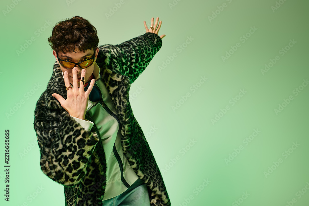 Fototapeta premium Stylish young man striking a fashionable pose in a vibrant setting