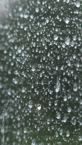 Vertical view of rain covered glass with macro detail