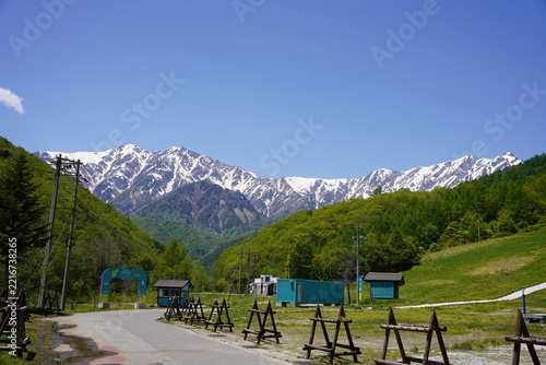 北アルプス　残雪の鹿島槍ヶ岳と新緑の里山	