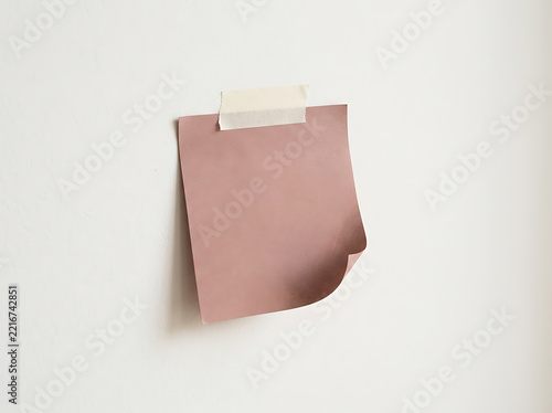 Pink sticky note taped to a wall
