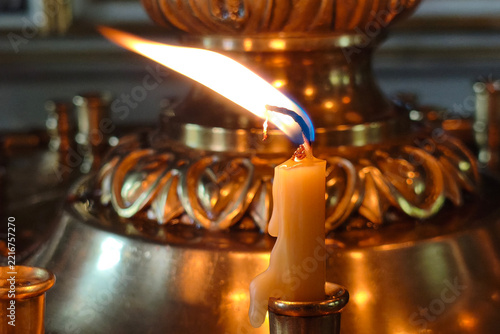 Obraz na plátně A candle burns in a holder, its flame flickering unevenly due to a draft