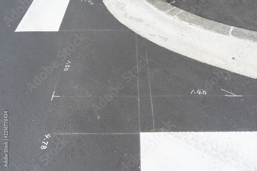 横断歩道を新設する道路工事で路面に位置出しと墨出しを行った跡