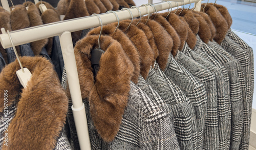 Winter jacket with a fur collar in the winter sales, hanging on a clothes rack
