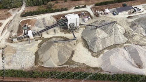 Aerial view of industrial gravel quarry with processing machinery and large piles of sand and gravel in Chivasso, Piedmont, Italy.
