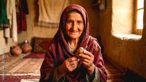 Elderly woman in traditional headscarf holding a small wooden