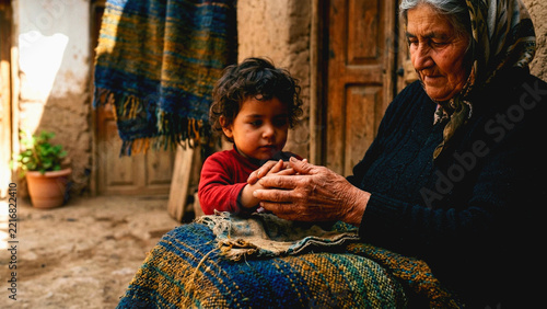 Elderly grandmother holding hands with her young grandchild in a