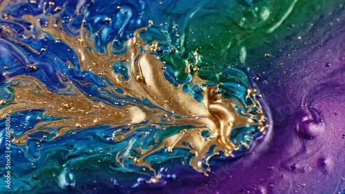 Close-up of swirling metallic gold paint in vibrant purple and green background