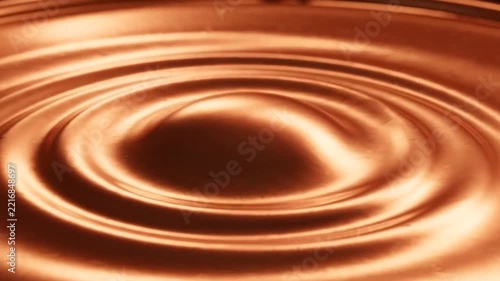 Close-up of water droplets creating ripples on a metallic surface