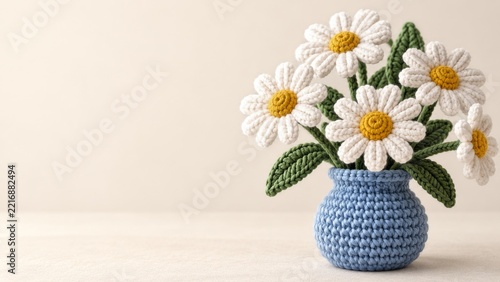 Crocheted white daisies in a blue knitted round vase with copy space