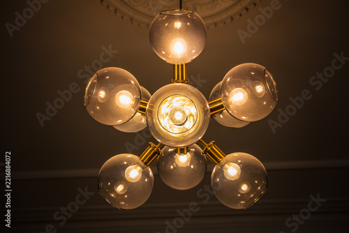 Interior light, a vintage style brass chandelier with glowing spherical glass shades