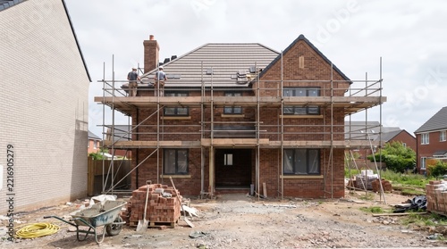 Brick house under construction with scaffolding and unfinished exterior