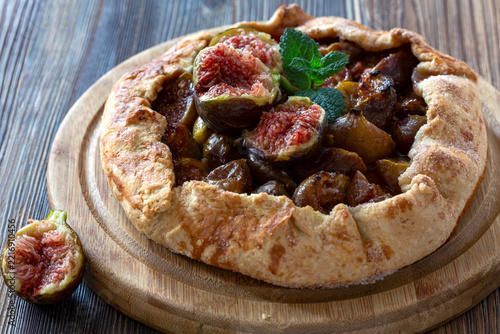 Fresh fig galette on wooden board with mint garnish