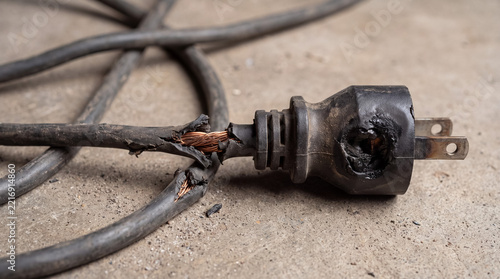 Damaged electrical cord showing frayed wires and burnt power plug creating a dangerous fire hazard