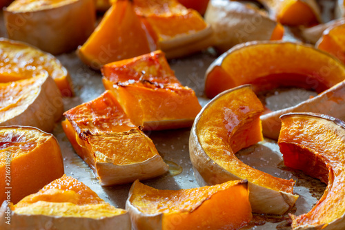 Roasted pumpkin slices on a baking tray with golden brown edges.